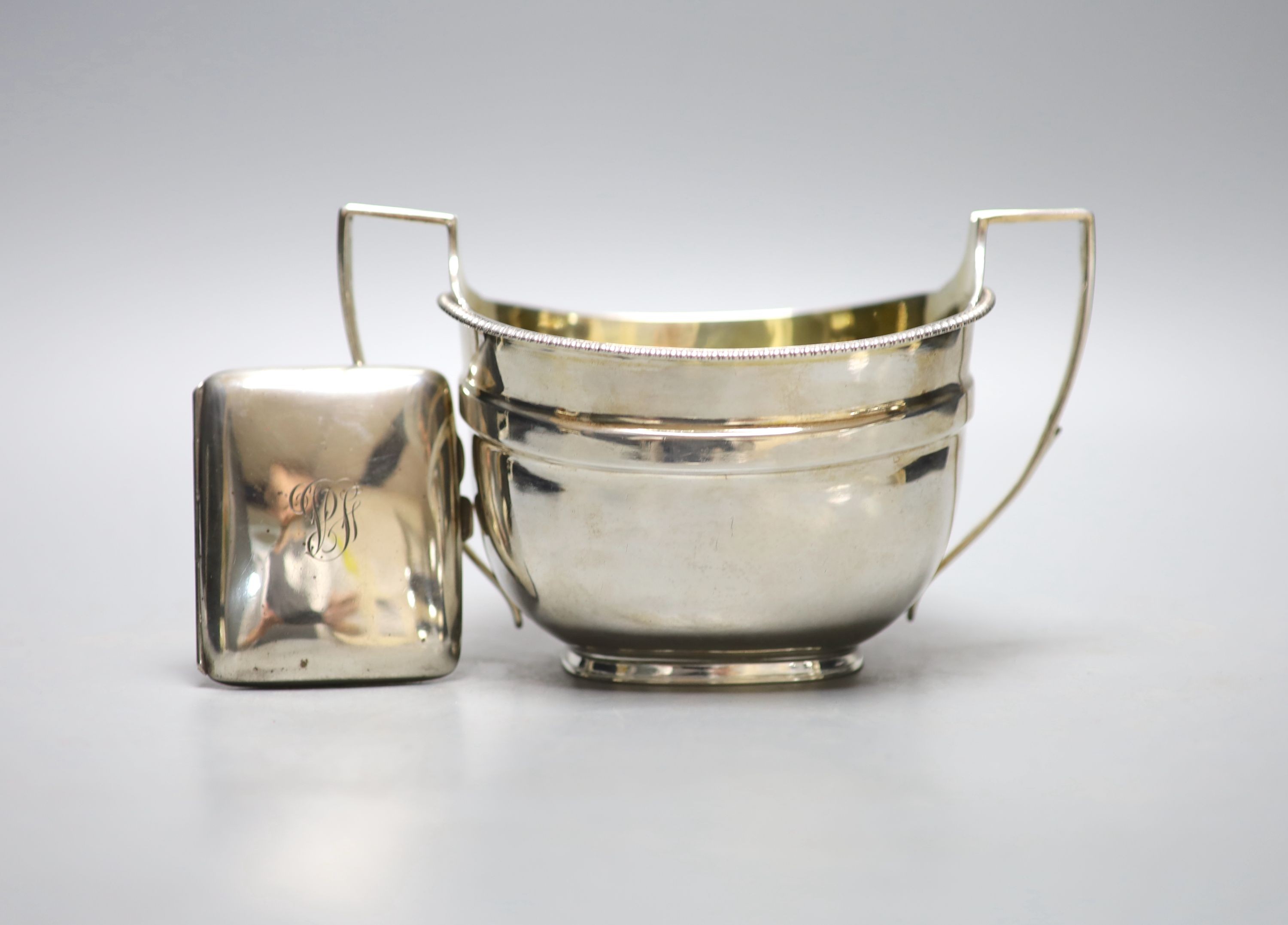 A George III silver two handled sugar bowl, John Emes, London, 1807, height 11.2cm, together with a later silver cigarette case, gross 11oz.